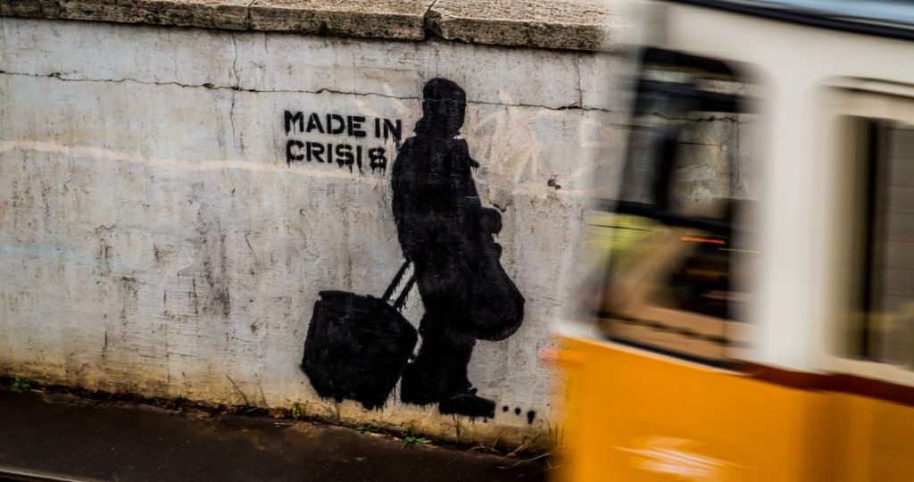 Image of graffiti on a wall that reads "Made in Crisis"